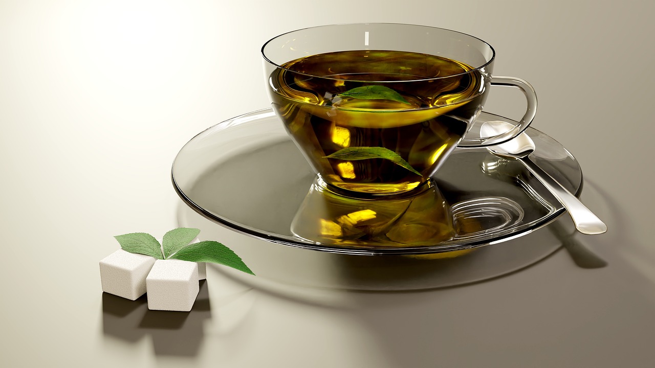 Tazza di tè verde fumante con foglie fresche, simbolo di benefici per colesterolo e pressione.