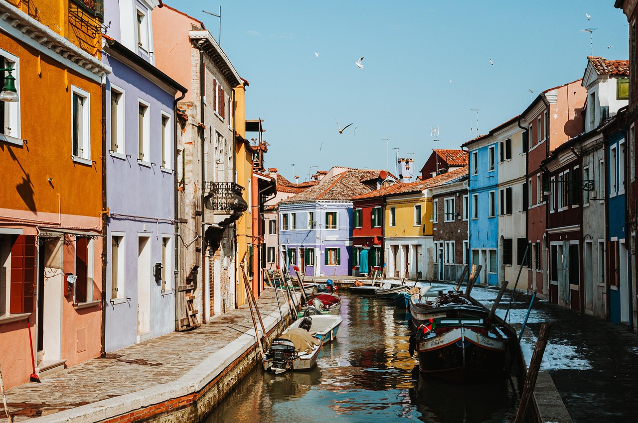 Vista panoramica di un'isola veneziana con tipiche case colorate e acque blu.