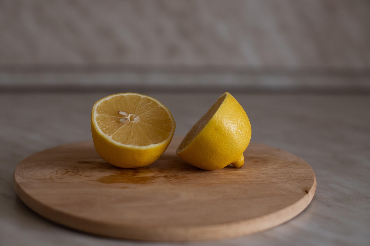 Limone fresco su un tagliere di legno, pronto per disinfettare e sbiancare la superficie.