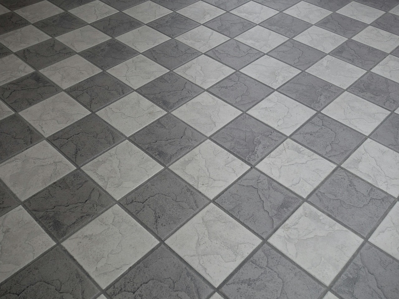 Immagine di piastrelle sovrapposte su un pavimento, illustrando la tecnica di installazione.