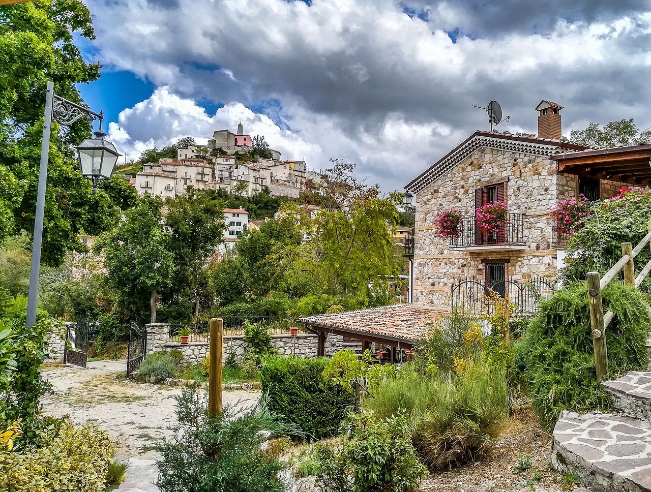 Panorama primaverile di un borgo abruzzese con fiori e architettura storica.